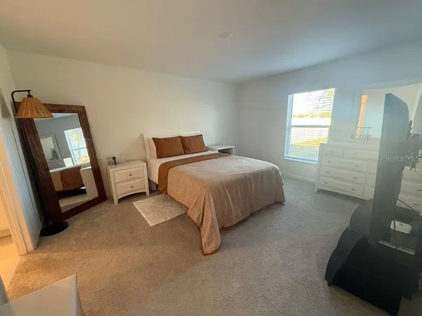 a spacious bedroom with a bed and wooden floor