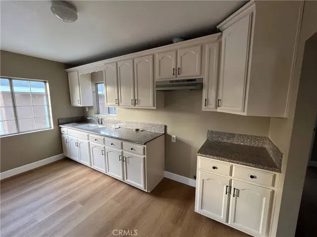 a kitchen with granite countertop white cabinets and white appliances