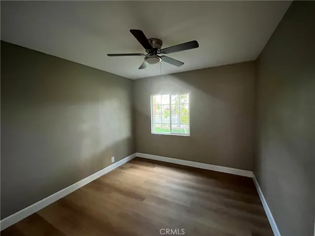 an empty room with a window and a fan