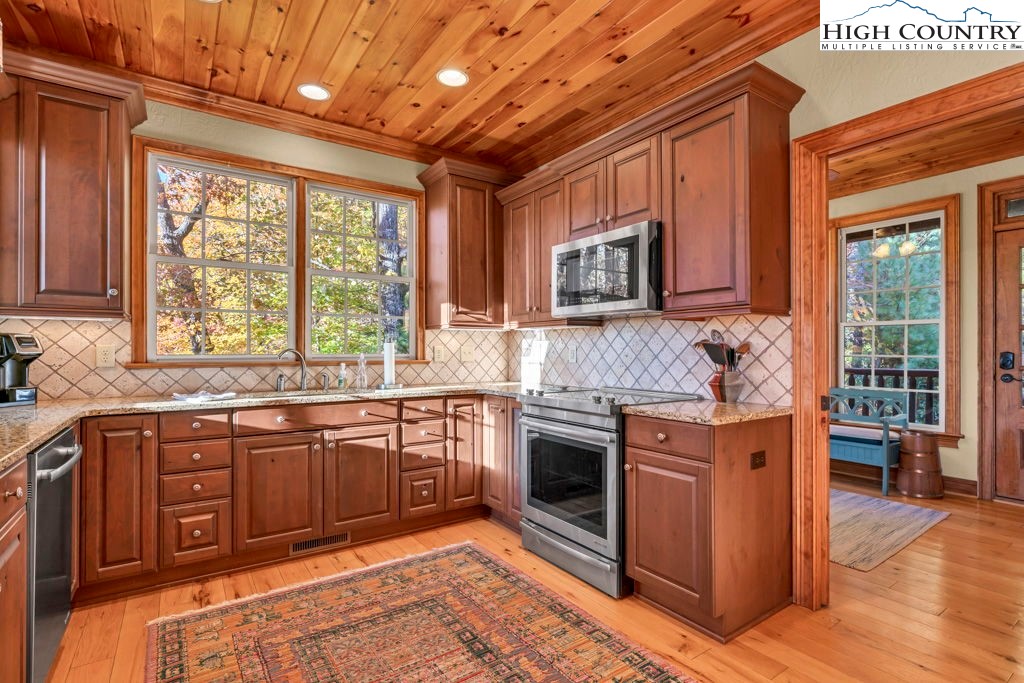 3664 Elk Ridge Road Ferguson, NC 28624 - Photo 21 of 46 a kitchen with stainless steel appliances granite countertop wooden cabinets a sink and a stove