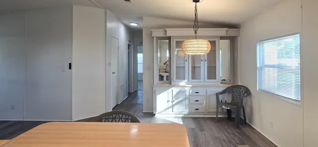a hallway with a chandelier and wooden floor