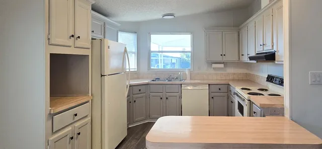 a kitchen with white cabinets and white appliances