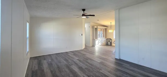 a view of a hallway with wooden floor and a chandelier