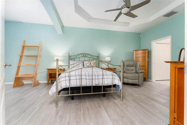 a bedroom with a bed and wooden floor