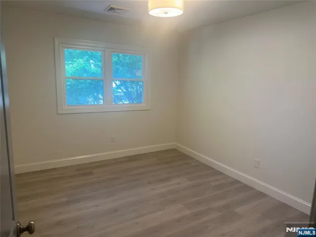 an empty room with wooden floor and window
