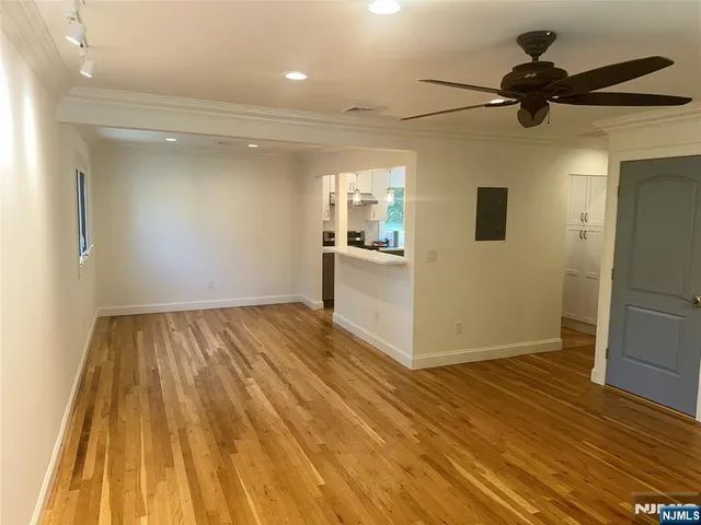 a view of a livingroom with a flesh screen tv and wooden floor