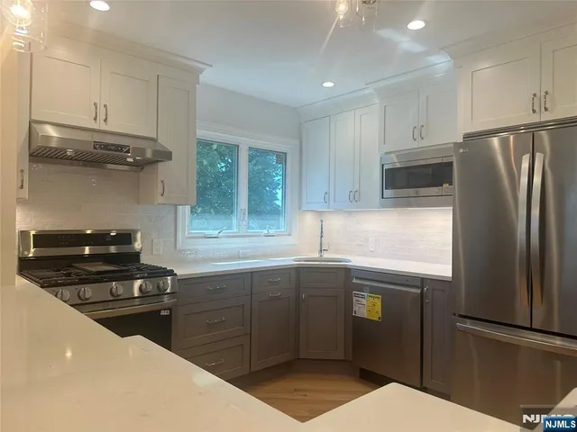 a kitchen with stainless steel appliances a sink cabinets and a refrigerator
