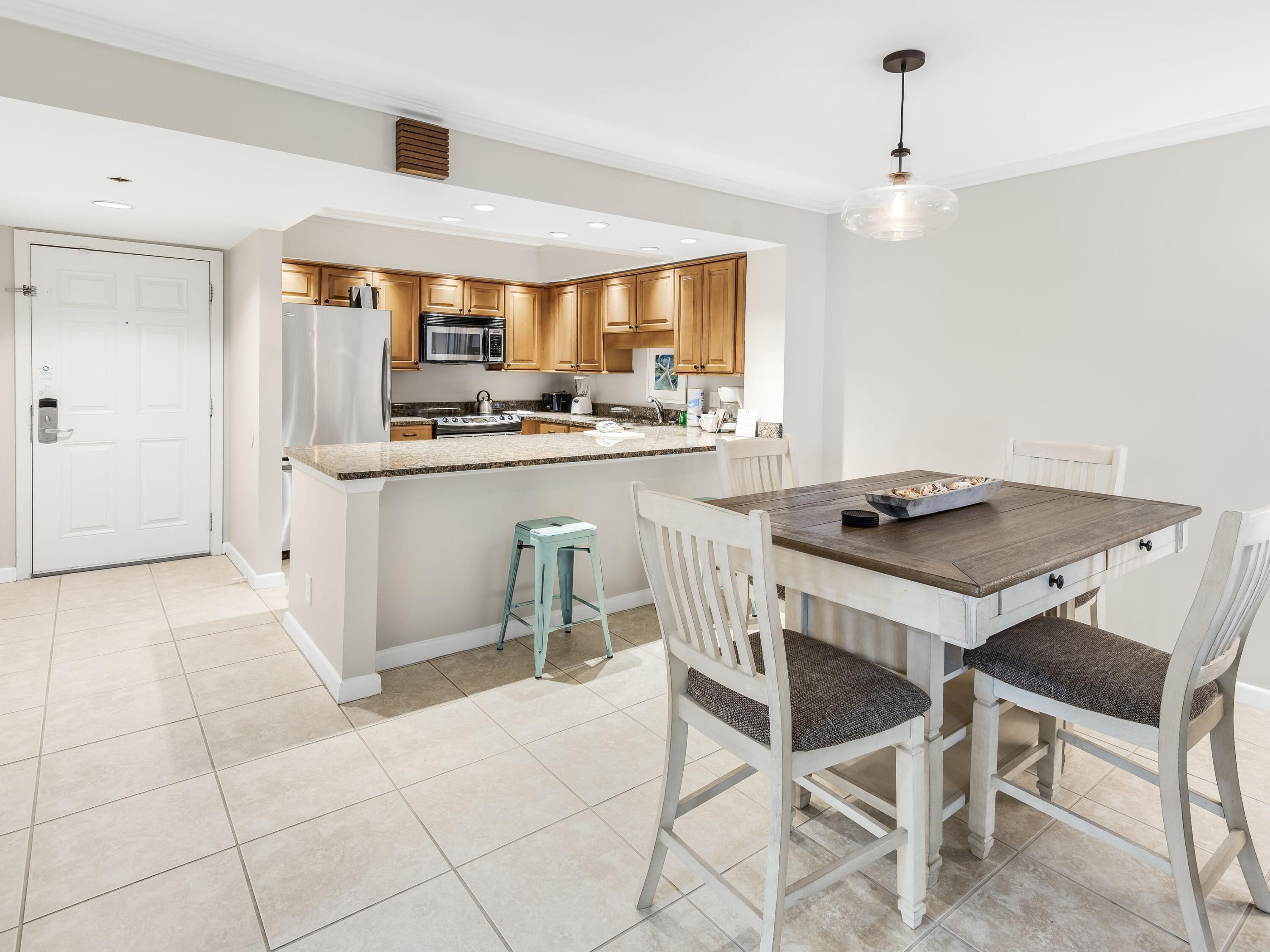 4218 Beachside 2, Unit 218 Miramar Beach, FL 32550 - Photo 7 of 29 a kitchen with stainless steel appliances granite countertop a sink and a refrigerator