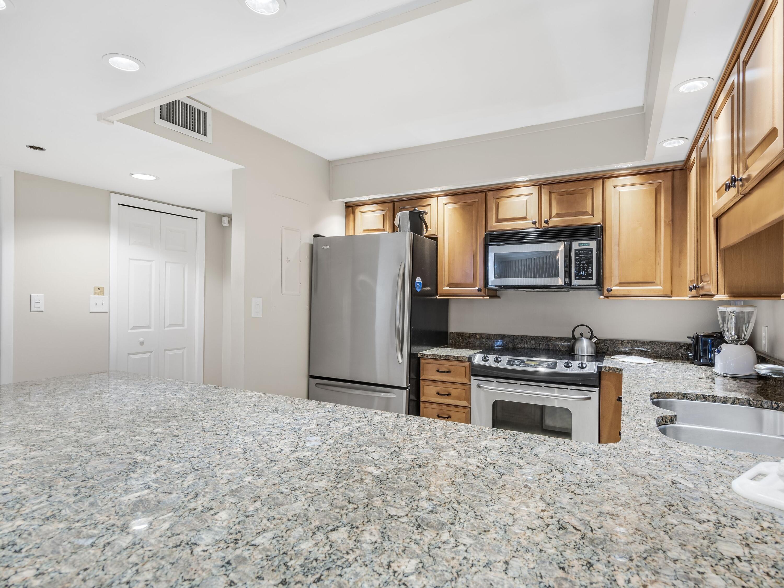 4218 Beachside 2, Unit 218 Miramar Beach, FL 32550 - Photo 9 of 29 a kitchen with stainless steel appliances granite countertop a refrigerator stove top oven and sink