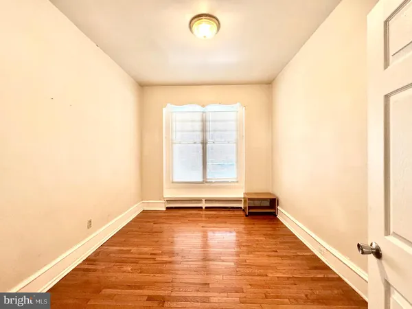 a view of a bathroom with a hallway and wooden floor