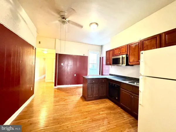 a kitchen with stainless steel appliances granite countertop a stove a refrigerator and a wooden floors