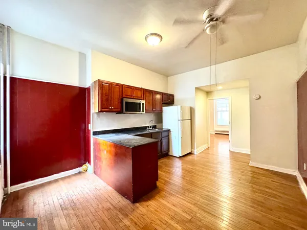 a kitchen with granite countertop wooden floors a refrigerator and a stove
