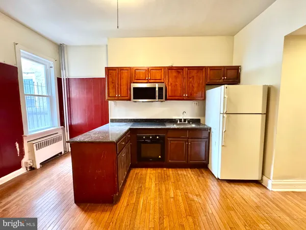 a view of a room with wooden floor and furniture