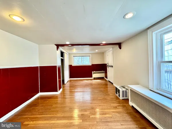 a view of empty room with wooden floor and cabinets