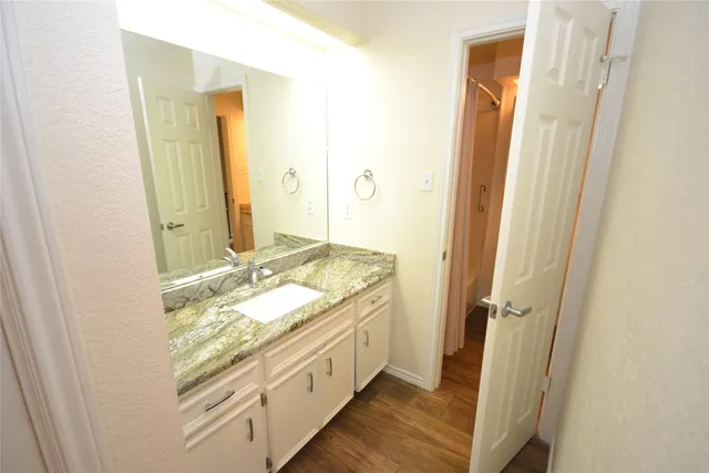a bathroom with a granite countertop sink and a mirror