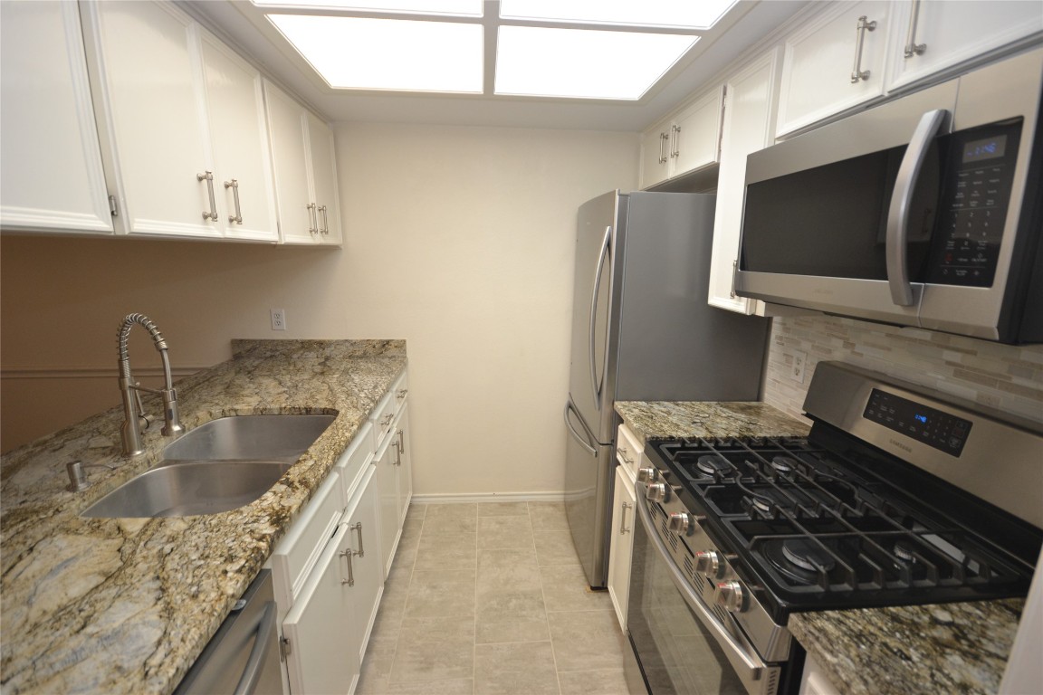500 Hesters Crossing Road, Unit 205 Round Rock, TX 78681 - Photo 4 of 18 a kitchen with granite countertop a sink stainless steel appliances and cabinets
