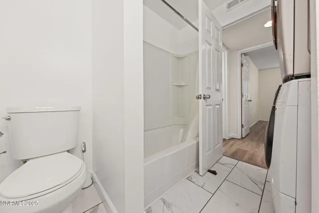 a bathroom with a granite countertop toilet and a shower