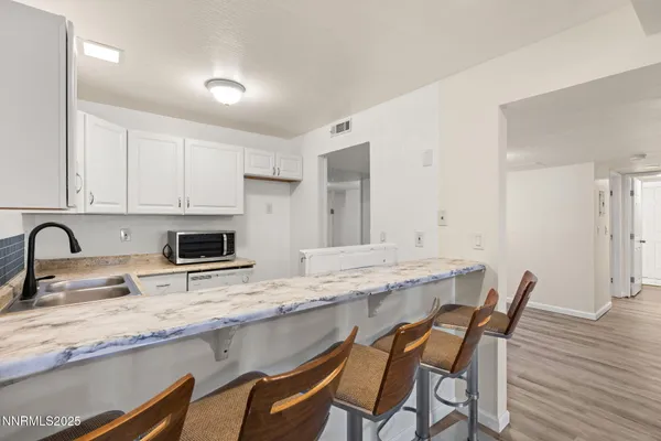 a kitchen with granite countertop white cabinets and chairs