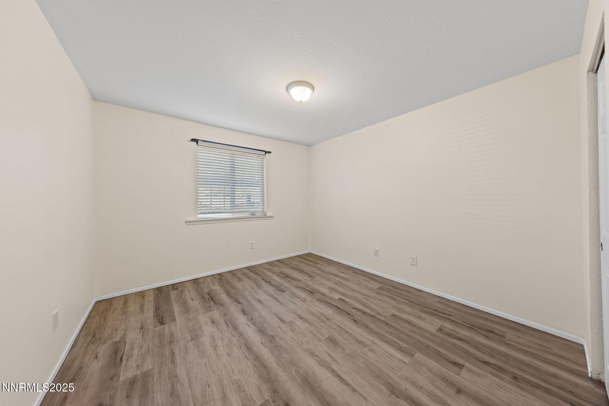 2555 Clear Acre Lane, Unit 161 Reno, NV 89512 - Photo 10 of 17 an empty room with wooden floor and windows