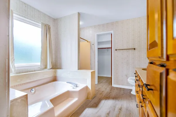 a bathroom with a granite countertop toilet sink and mirror