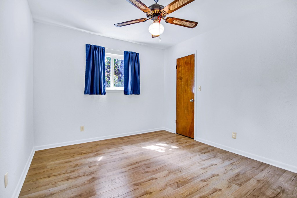 298 Jenkins Road Cedar Creek, TX 78612 - Photo 21 of 40 a view of an empty room with window and wooden floor