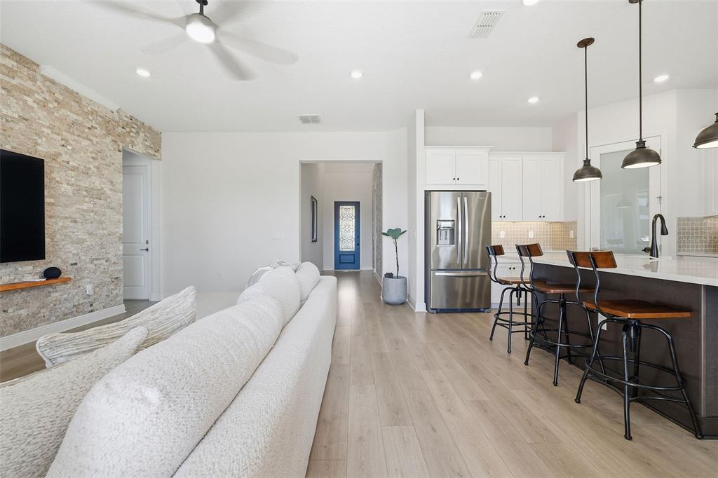 16131 Volterra Point Bella Collina, FL 34756 - Photo 23 of 52 a living room with stainless steel appliances kitchen island granite countertop furniture and a wooden floor