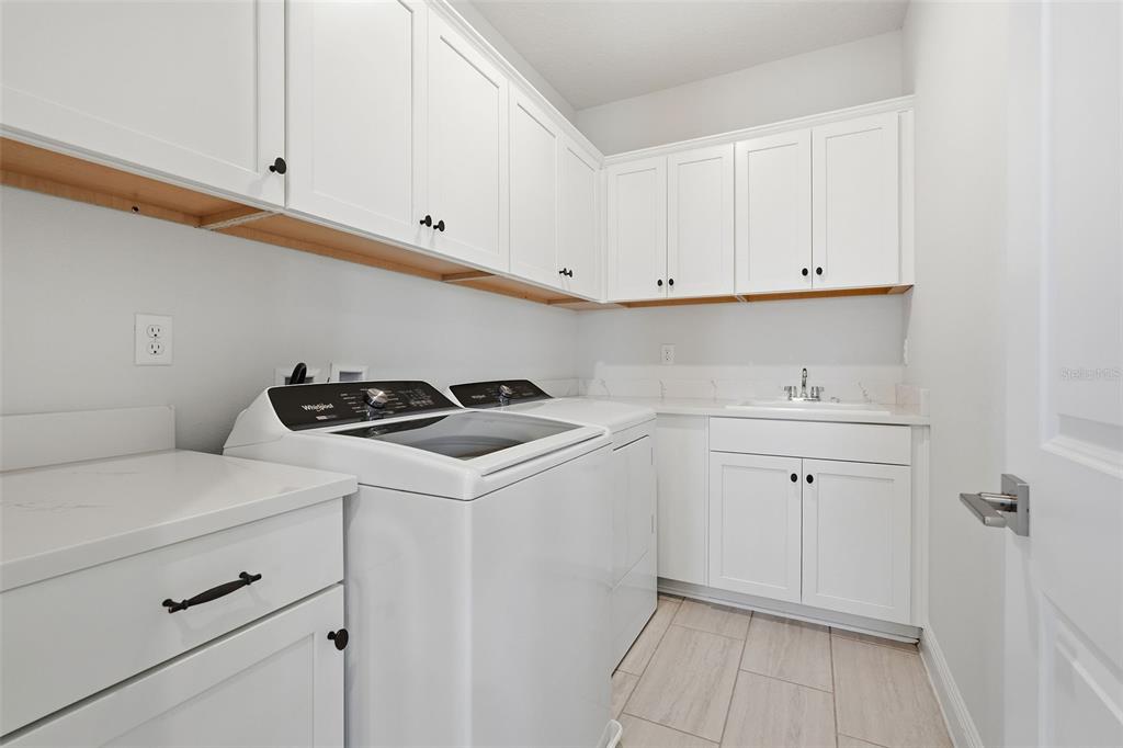 16131 Volterra Point Bella Collina, FL 34756 - Photo 34 of 52 a utility room with cabinets washer and dryer