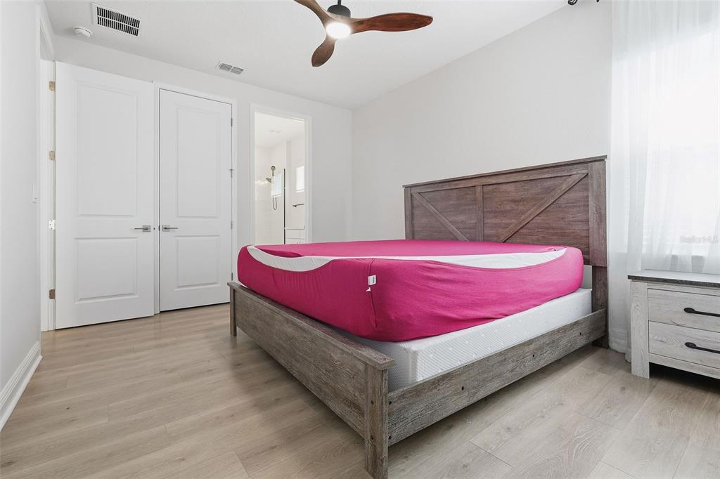 16131 Volterra Point Bella Collina, FL 34756 - Photo 41 of 52 a spacious bedroom with a bed and a chandelier