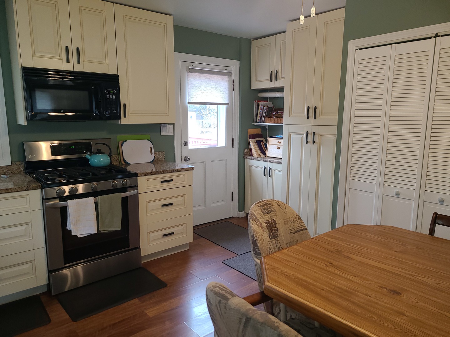 6806 Maple Court Bridgeview, IL 60455 - Photo 11 of 26 a kitchen with stainless steel appliances kitchen island granite countertop a stove a sink and a microwave