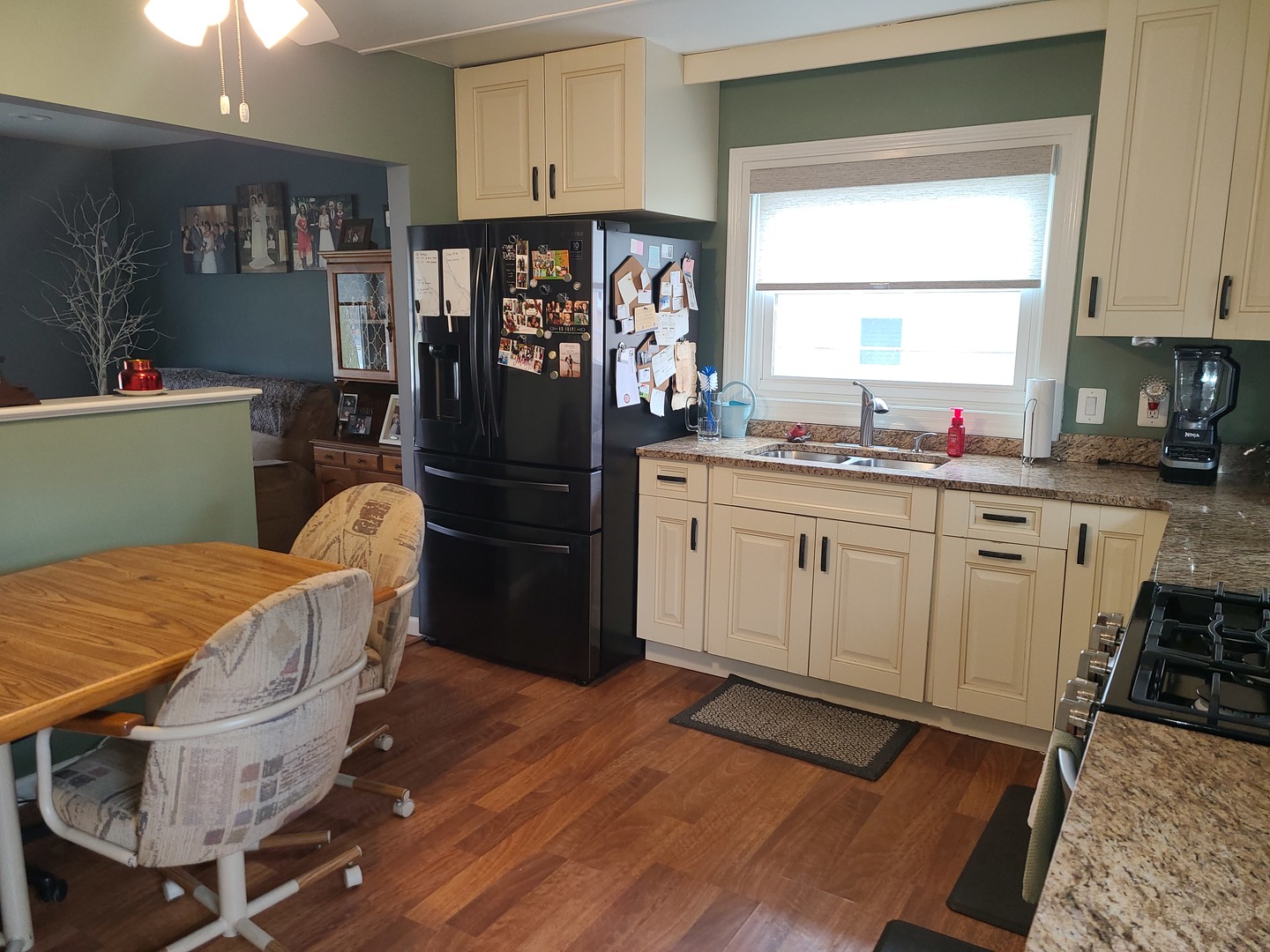 6806 Maple Court Bridgeview, IL 60455 - Photo 13 of 26 a kitchen with stainless steel appliances kitchen island granite countertop a refrigerator a sink dishwasher a dining table and chairs with wooden floor