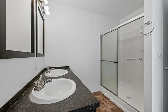 a bathroom with a sink a mirror and shower