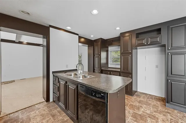 a kitchen with stainless steel appliances granite countertop a sink and a refrigerator