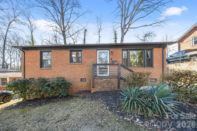 a view of a house with a large window and potted plants