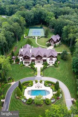 an aerial view of a house with swimming pool patio and lake view