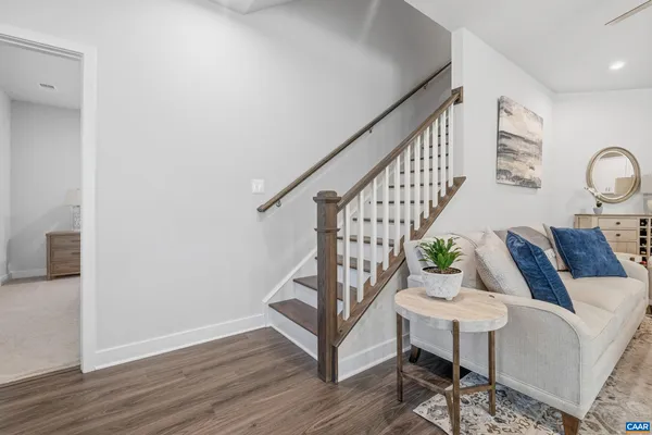 a living room with wooden floor and stairs