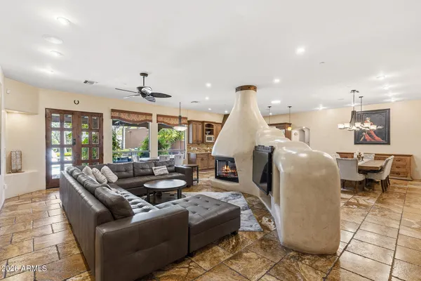 a kitchen with stainless steel appliances granite countertop a stove top oven a sink a dining table and chairs with wooden floor