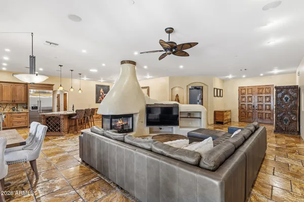 a kitchen with stainless steel appliances granite countertop a stove a sink dishwasher a dining table and chairs with wooden floor