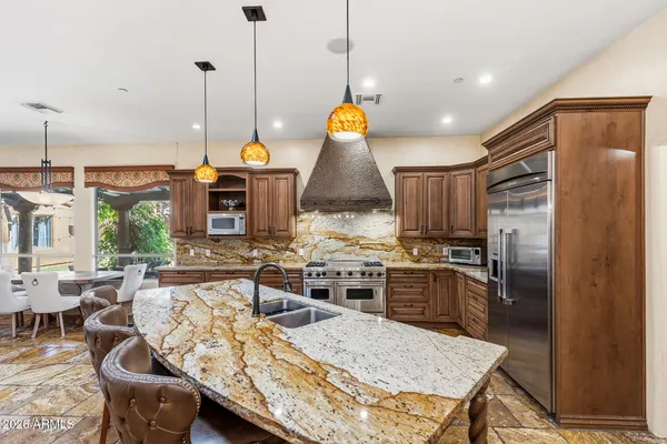 a bathroom with a granite countertop sink a bathtub and a large mirror