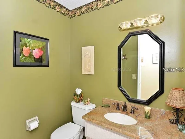 a bathroom with a granite countertop sink mirror and toilet