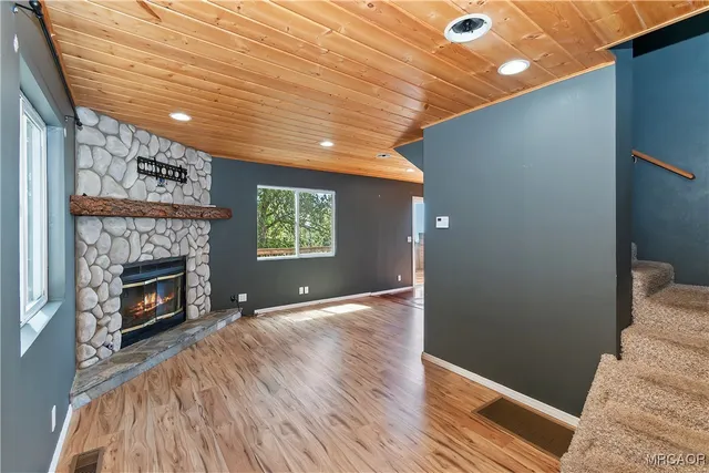 a view of an empty room with a window and fire place