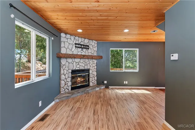 a view of an empty room with a fireplace and a window