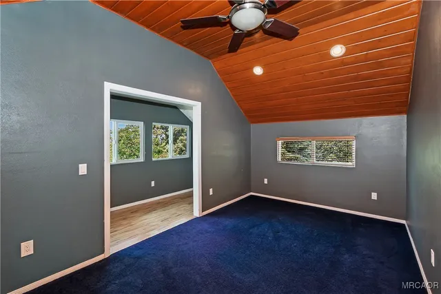 a view of a bedroom with wooden floor and a window