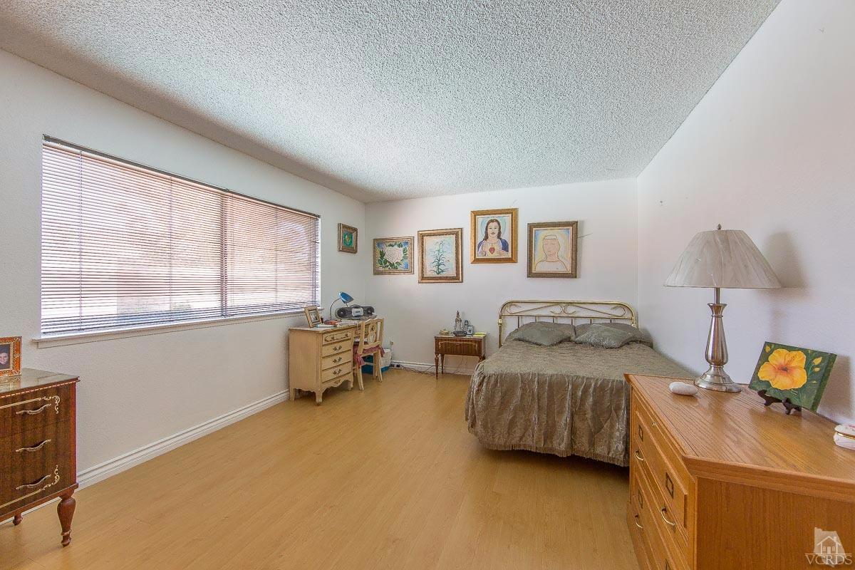 6128 Al Way Simi Valley, CA 93063 - Photo 16 of 27 a bedroom with a bed and wooden floor