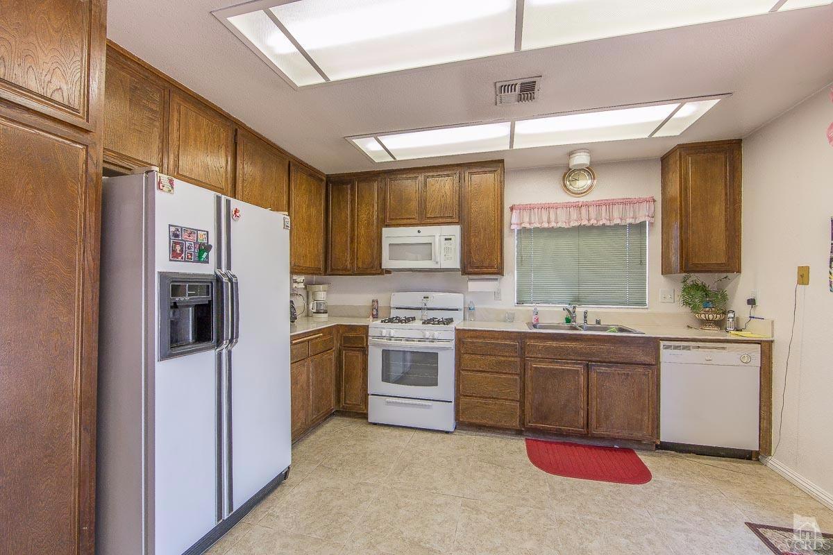 6128 Al Way Simi Valley, CA 93063 - Photo 7 of 27 a kitchen with stainless steel appliances granite countertop a sink stove and refrigerator