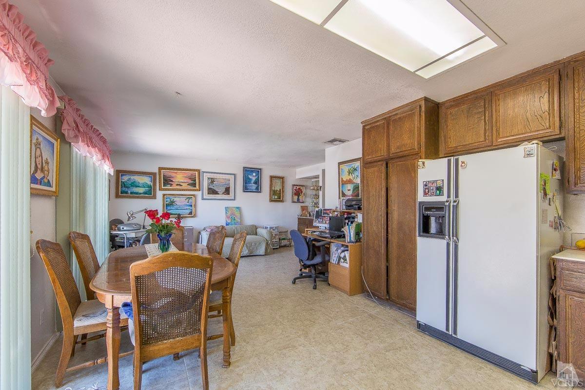 6128 Al Way Simi Valley, CA 93063 - Photo 8 of 27 a dining room with furniture a refrigerator and a kitchen view