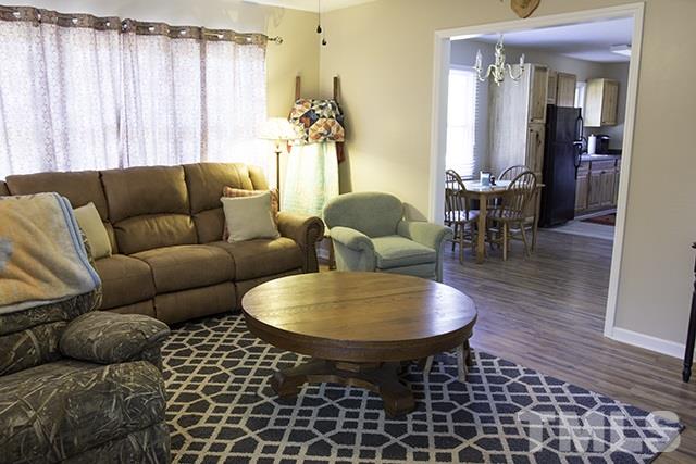 860 Reuben Allen Road Roxboro, NC 27574 - Photo 3 of 17 a living room with furniture a dining table and a chandelier