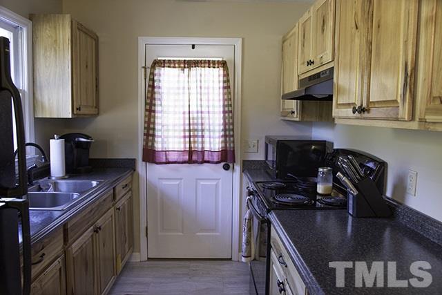 860 Reuben Allen Road Roxboro, NC 27574 - Photo 9 of 17 a kitchen with stainless steel appliances granite countertop a sink stove and refrigerator