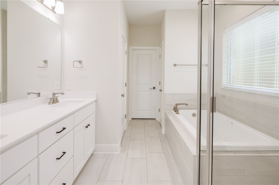 4302 Appalachian Trail Bryan, TX 77802 - Photo 12 of 25 a bathroom with a double vanity sink and mirror with shower