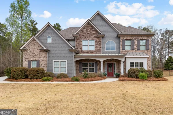 a front view of a house with yard and tress