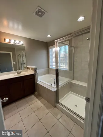 a bathroom with a tub a sink and a mirror